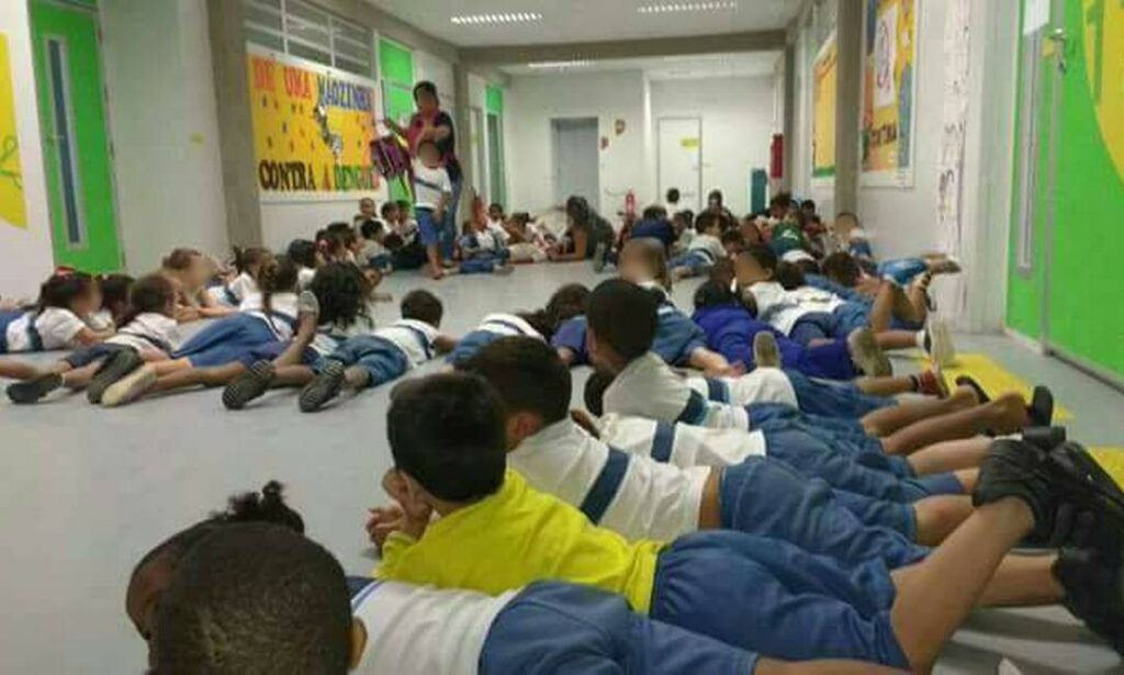 crianças agachadas na sala de aula durante tiroteio